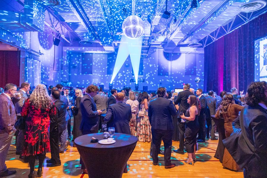 Ballroom transformed with blue uplighting and mirror-ball effects at a Primo event