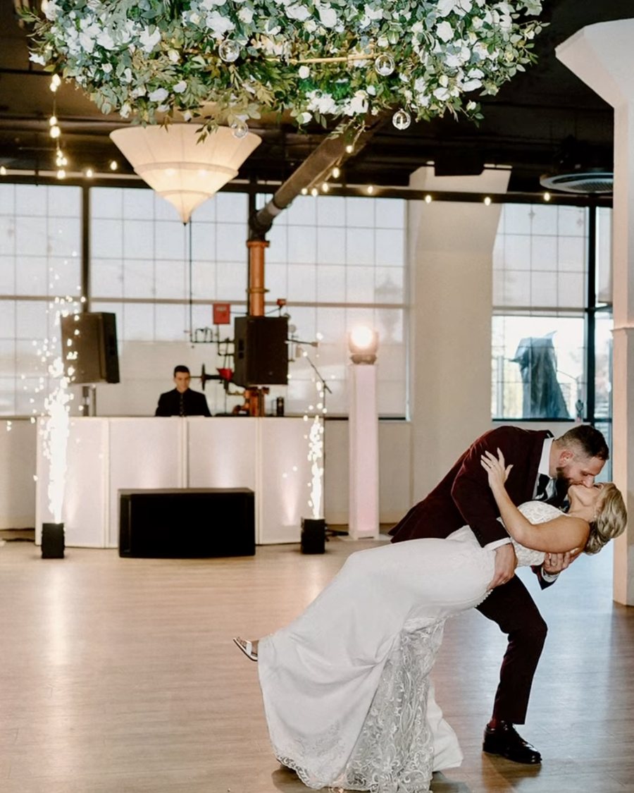 A couple sharing their first dance dip as cold sparks fire behind them and the Primo DJ plays